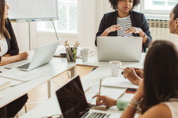 Woman reviewing business strategy on laptop during mid-year planning session